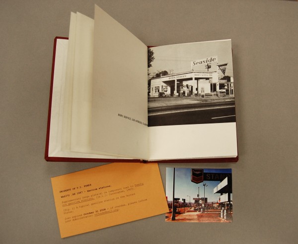 Photograph showing the book Twentysix Gasoline Stations by Edward Ruscha, along with the envelop and photograph placed inside as part of the V.I. Fonds project.