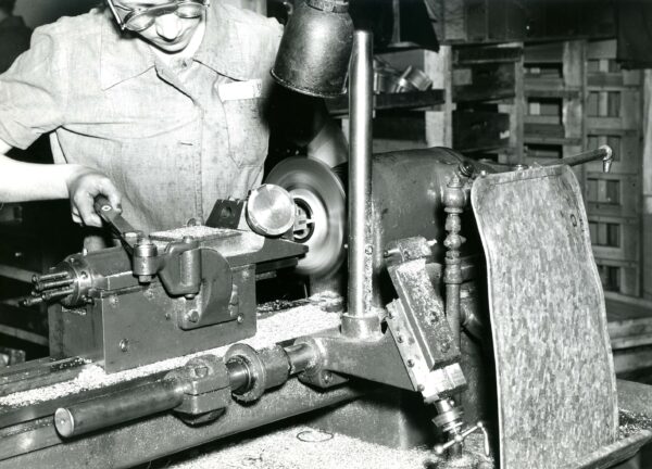 Black and white images of a women using an industrial machine