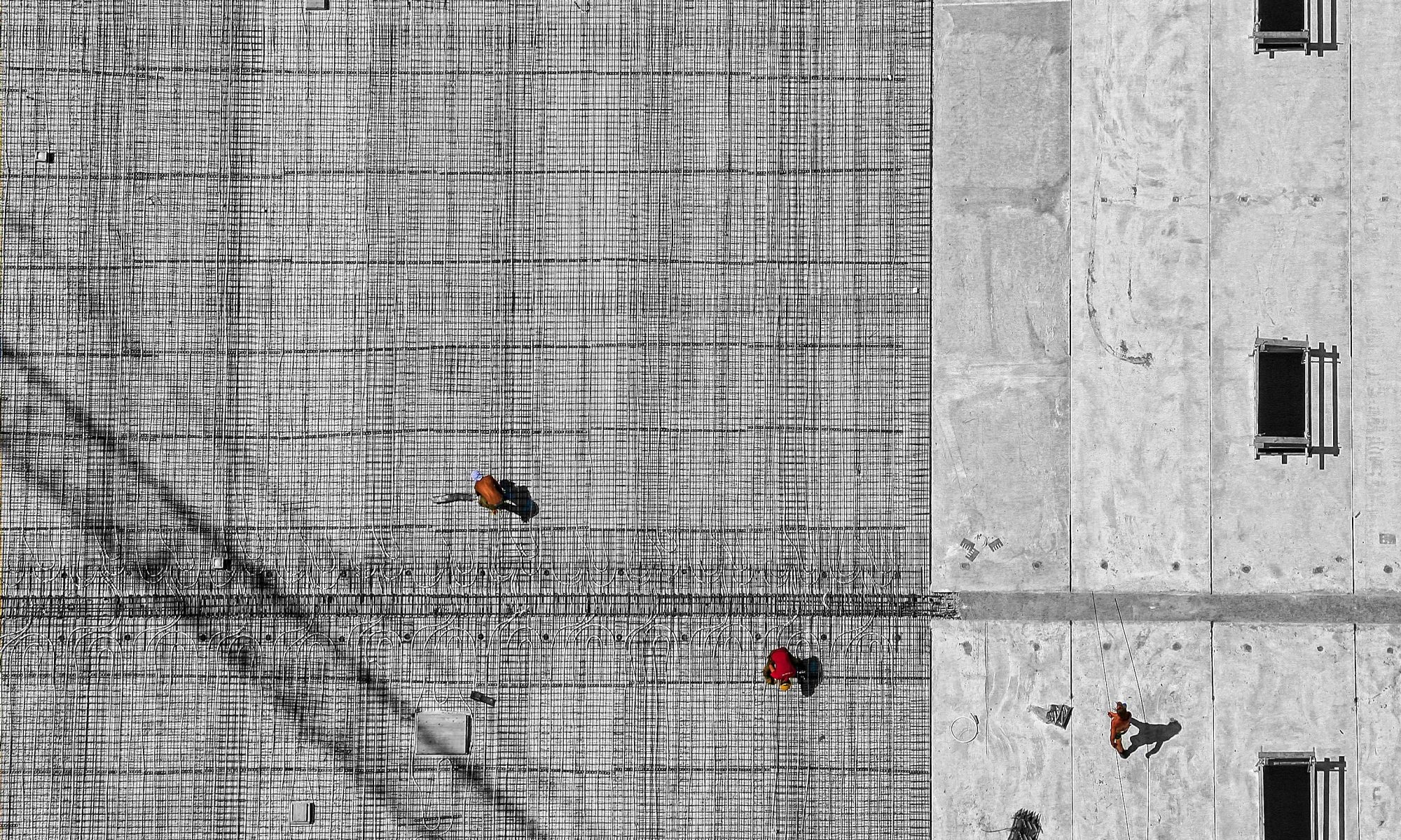 Workers on a concrete wall.